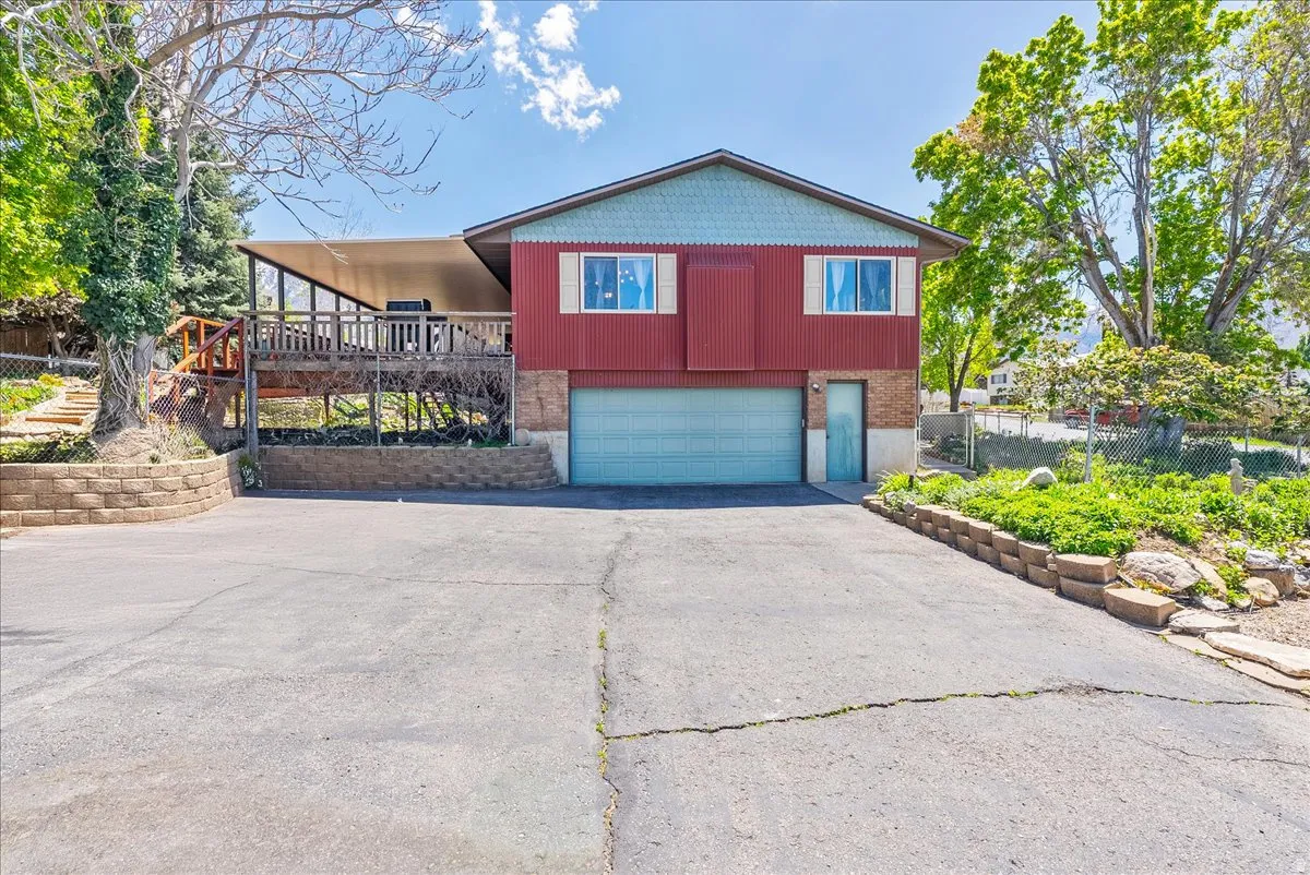 View of front of home featuring a garage, driveway, and a deck