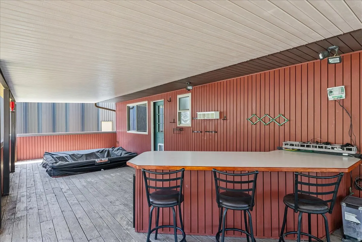 View of patio with exterior bar and a wall