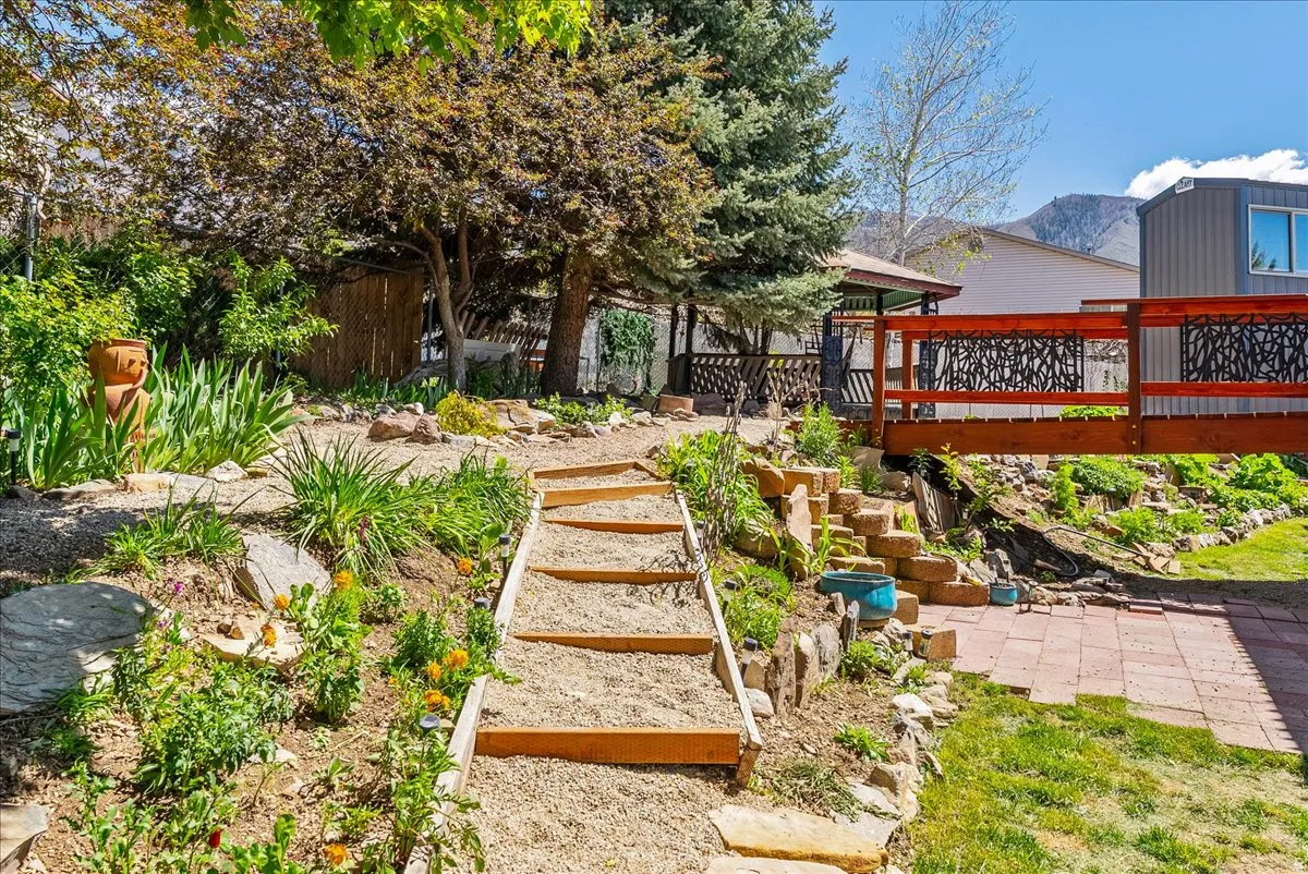 View of yard featuring stairs and a deck with mountain view