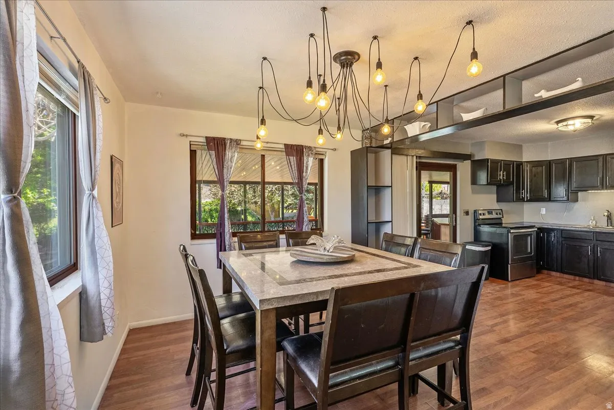 Dining space with dark wood finished floors and hanging lights