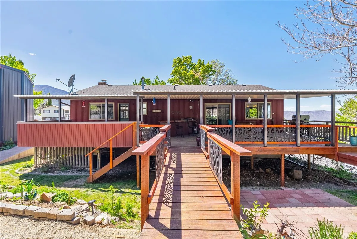 Rear view of property with a deck with mountain view and a shingled roof