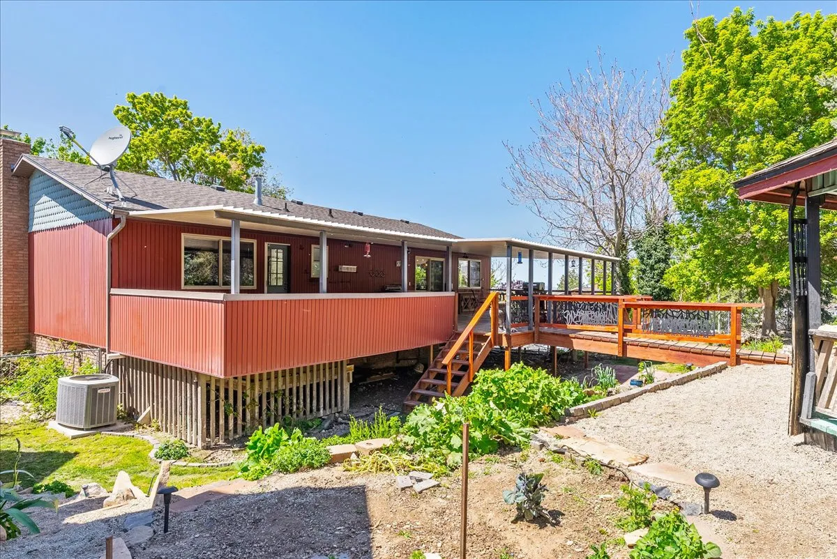 Rear view of house featuring a deck and a shingled roof