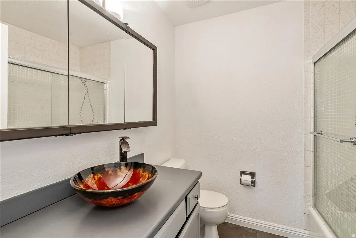 Bathroom featuring vanity, an enclosed shower, and a textured wall