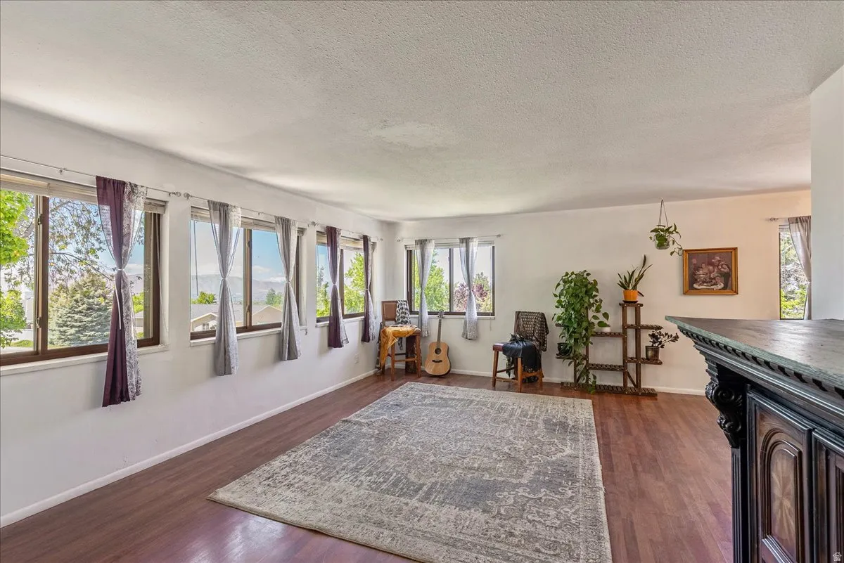 Living area featuring dark wood-style flooring and a textured ceiling