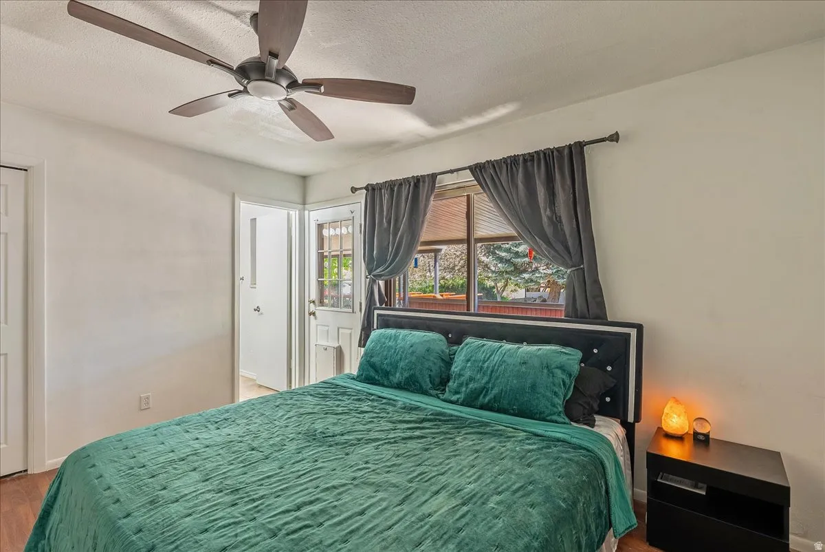 Bedroom featuring a textured ceiling, ceiling fan, and light wood finished floors
