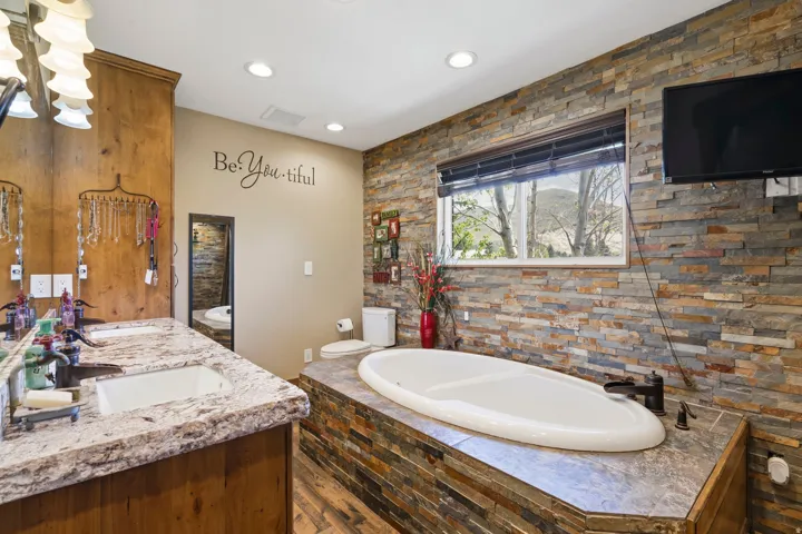 Full bathroom featuring double vanity and a garden tub