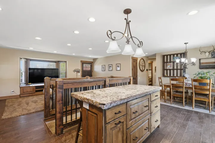 Kitchen featuring a kitchen island, dark wood-style floors, a kitchen bar, and wood finish cabinetry