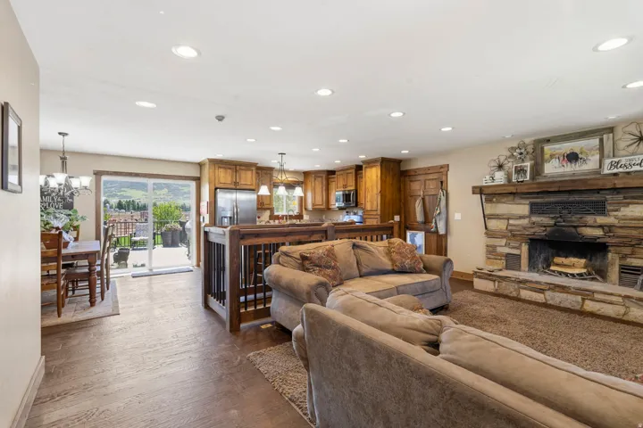 Living room featuring suspended lighting, dark wood-type flooring, and a fireplace