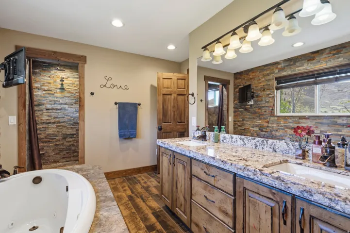 Bathroom with double vanity and a tub with jets