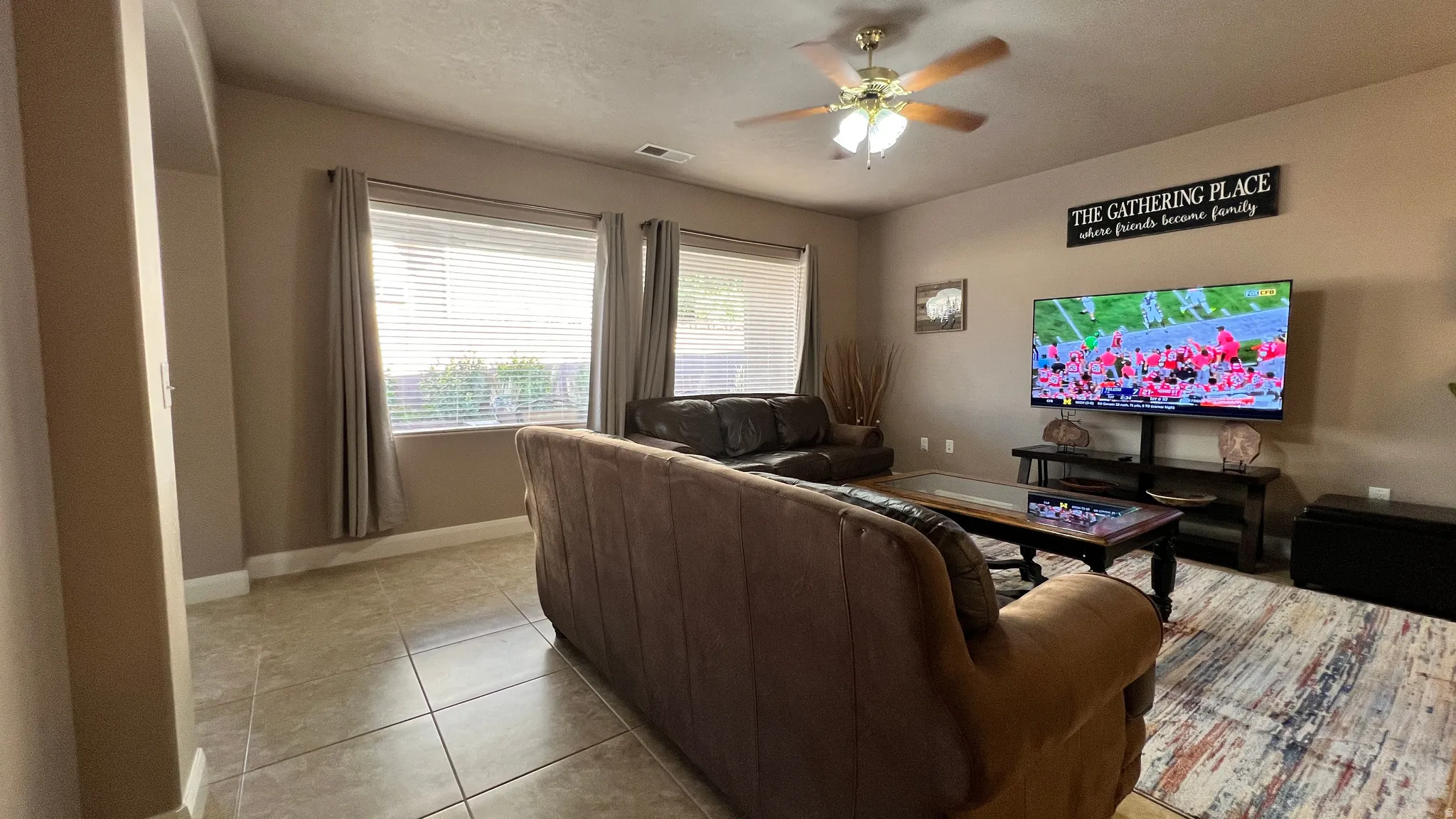 Living room featuring a ceiling fan and light tile patterned floors