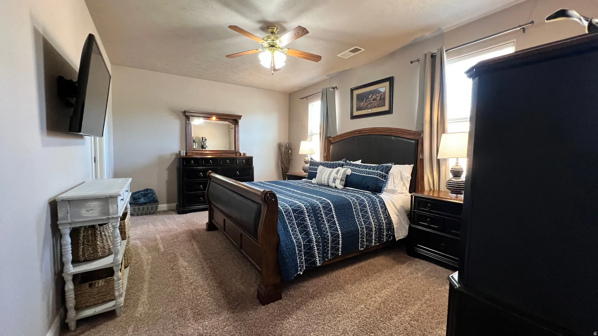 Bedroom with dark colored carpet and ceiling fan