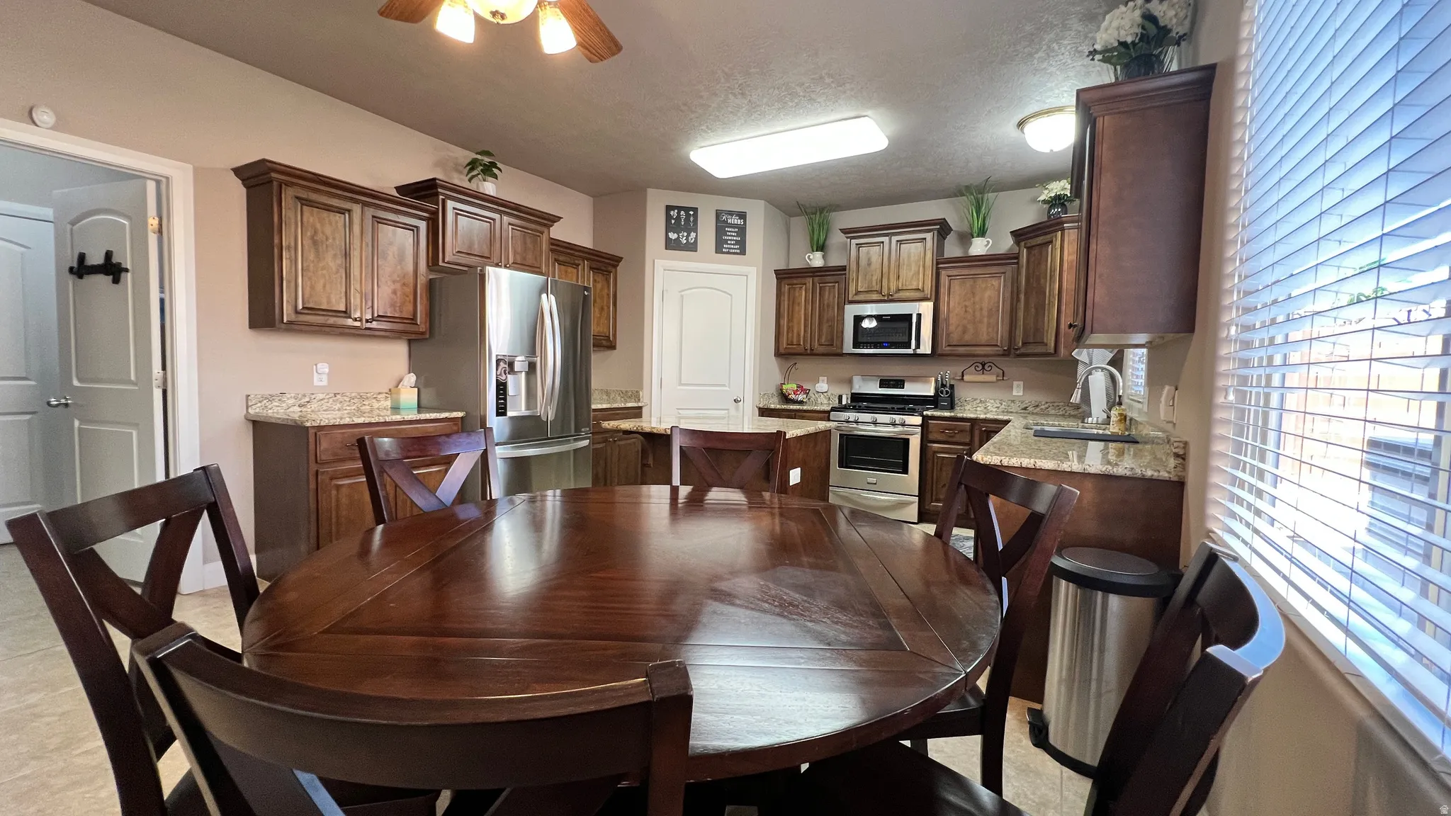 Dining room featuring ceiling fan and a textured ceiling