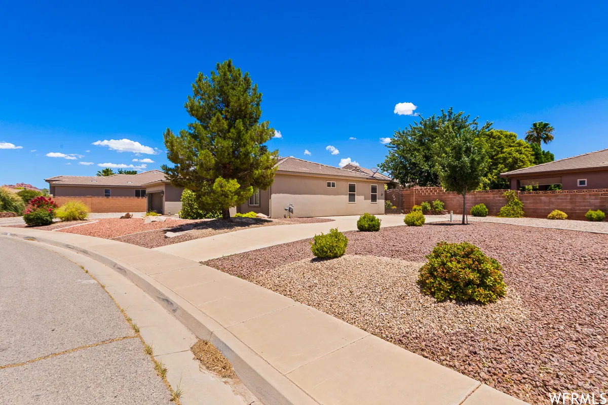 View of front of house featuring stucco siding and concrete driveway