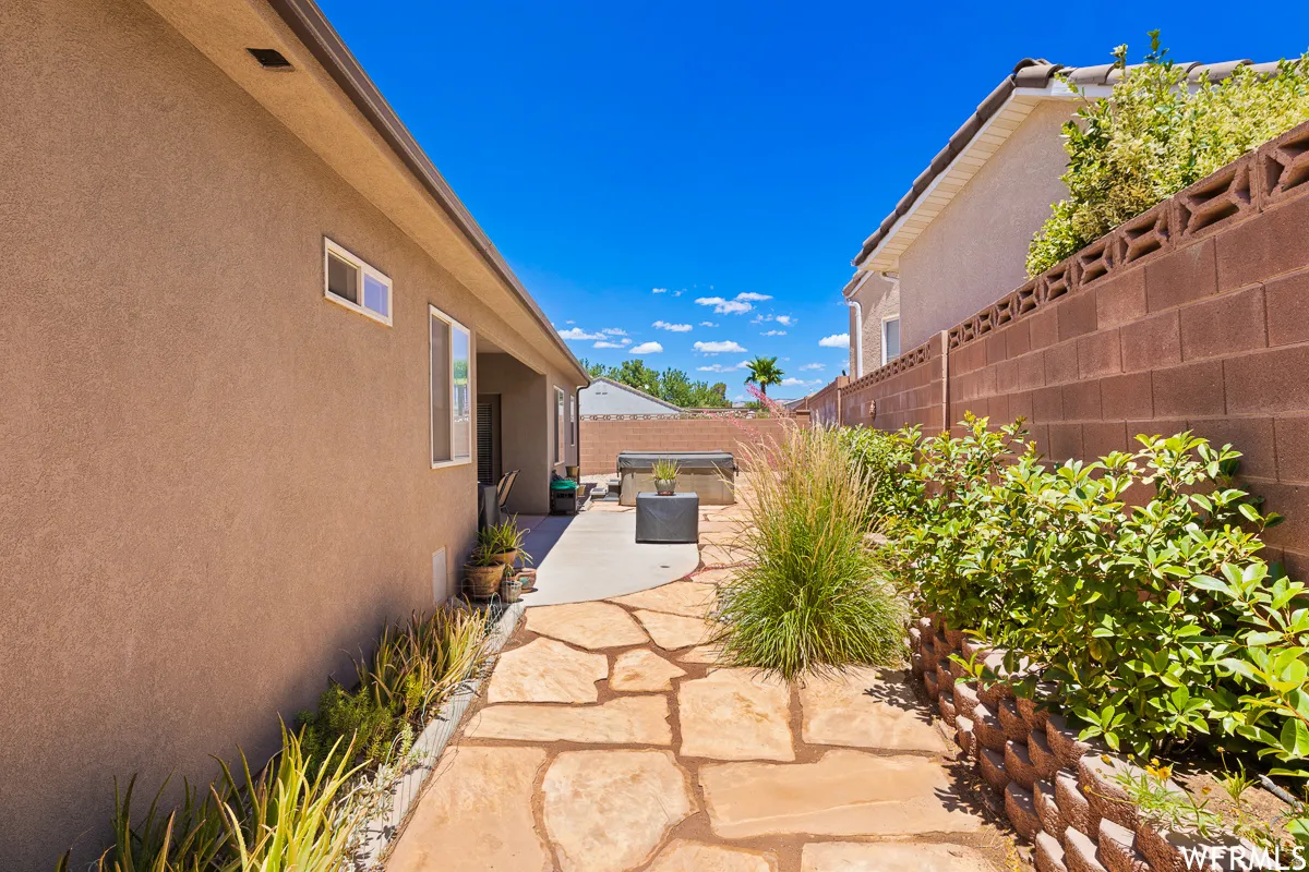 Fenced backyard with a hot tub and a patio