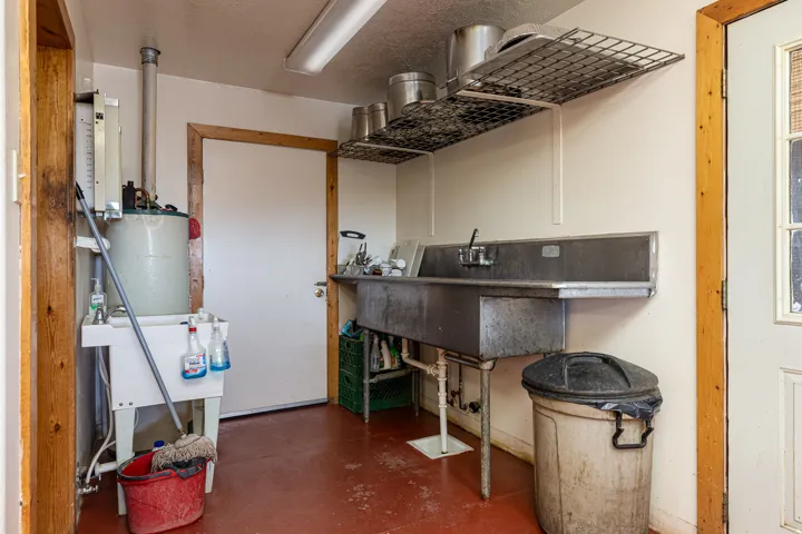 Misc room featuring finished concrete floors and water heater