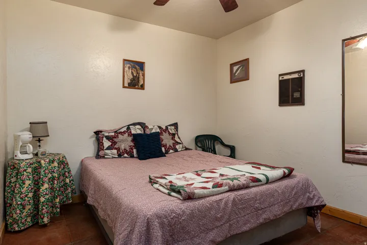 Bedroom with a textured wall and ceiling fan