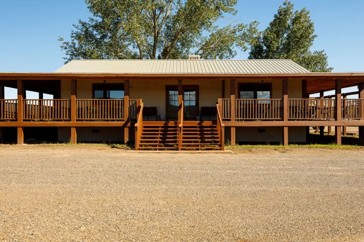 View of front of house with crawl space, covered porch, and a metal roof