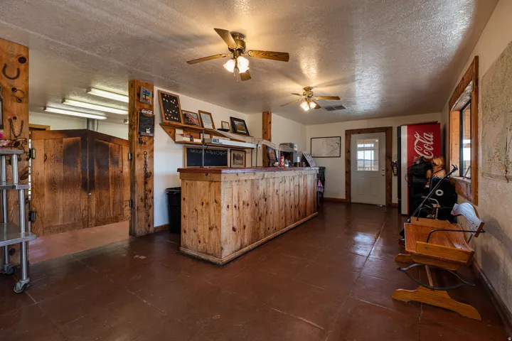Kitchen featuring a textured ceiling, a ceiling fan, and wood finish cabinets