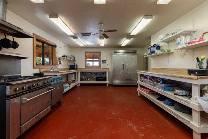 Kitchen featuring open shelves, a textured ceiling, high quality appliances, and ceiling fan