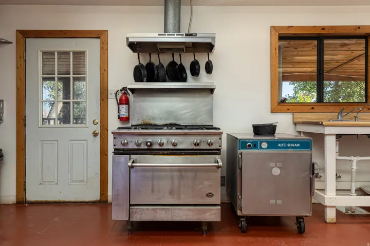 Kitchen with high end range, extractor fan, and concrete flooring