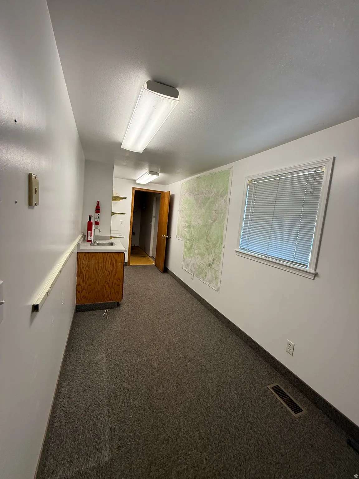 Corridor with dark carpet and a textured ceiling