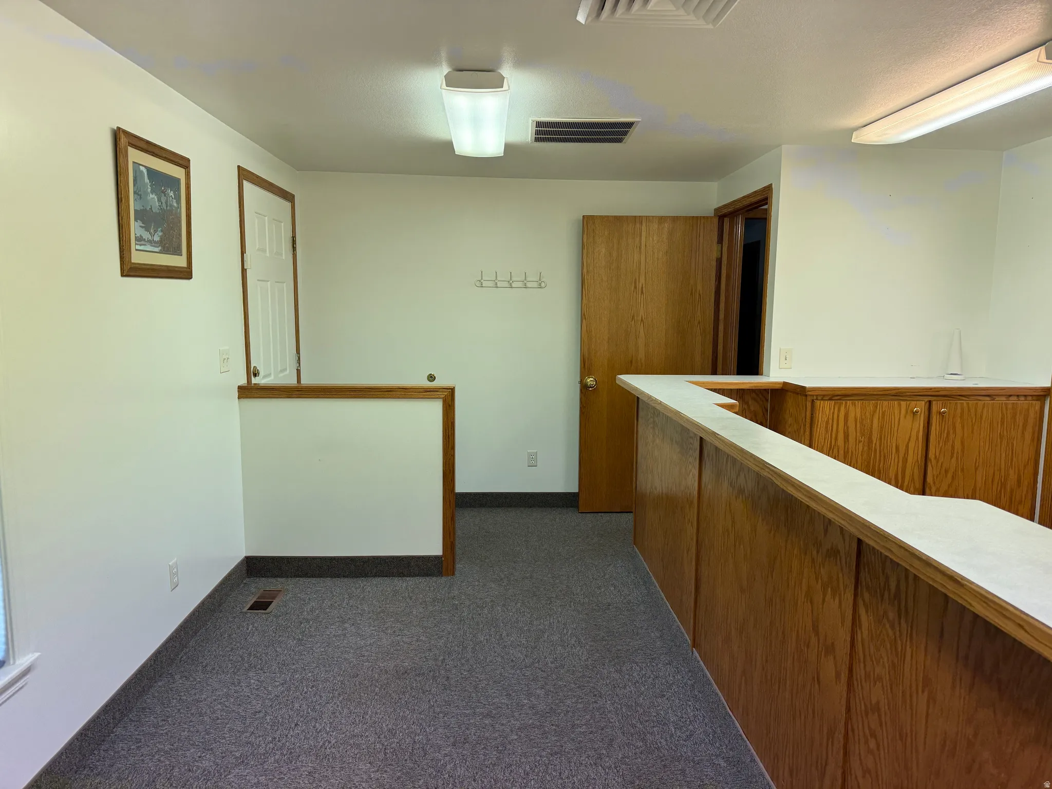 Hall with dark carpet and baseboards