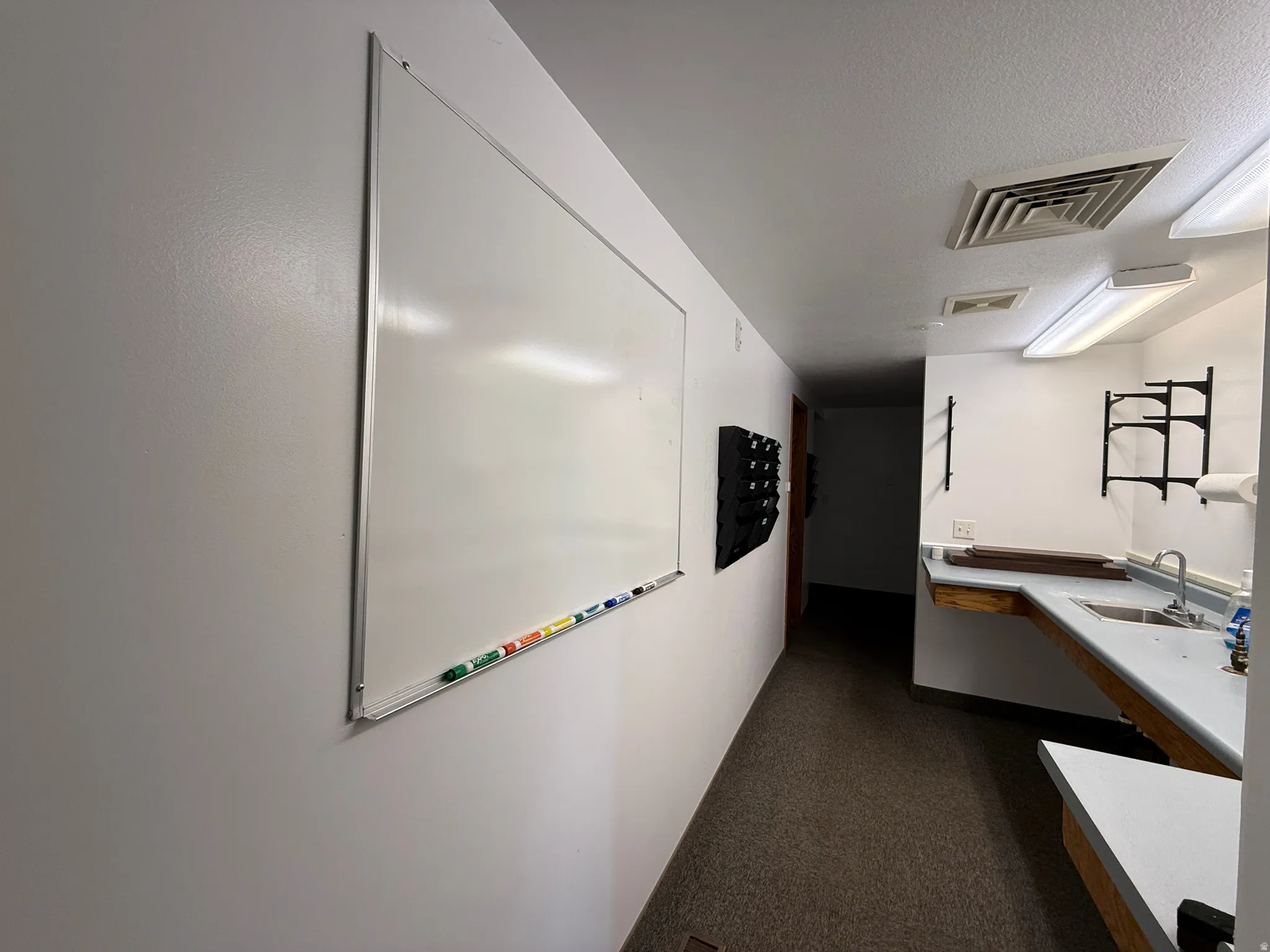 Corridor with a sink and a textured ceiling