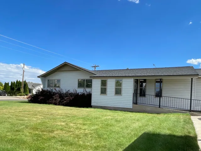 Rear view of house with a lawn and a shingled roof