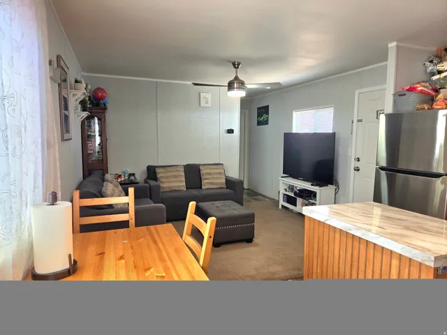 Living area with ornamental molding and ceiling fan