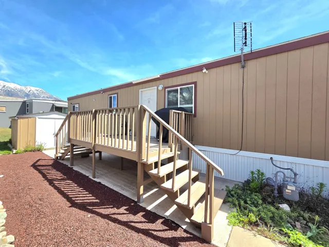 Back of house with a deck with mountain view and a shed