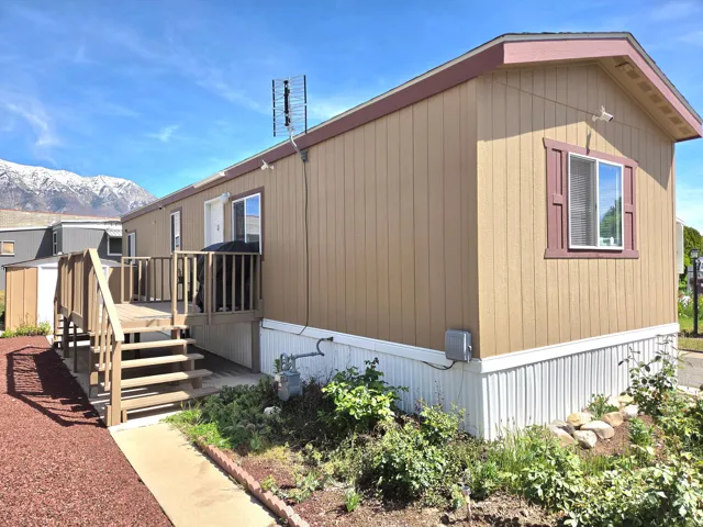 View of side of home featuring a deck with mountain view and stairs