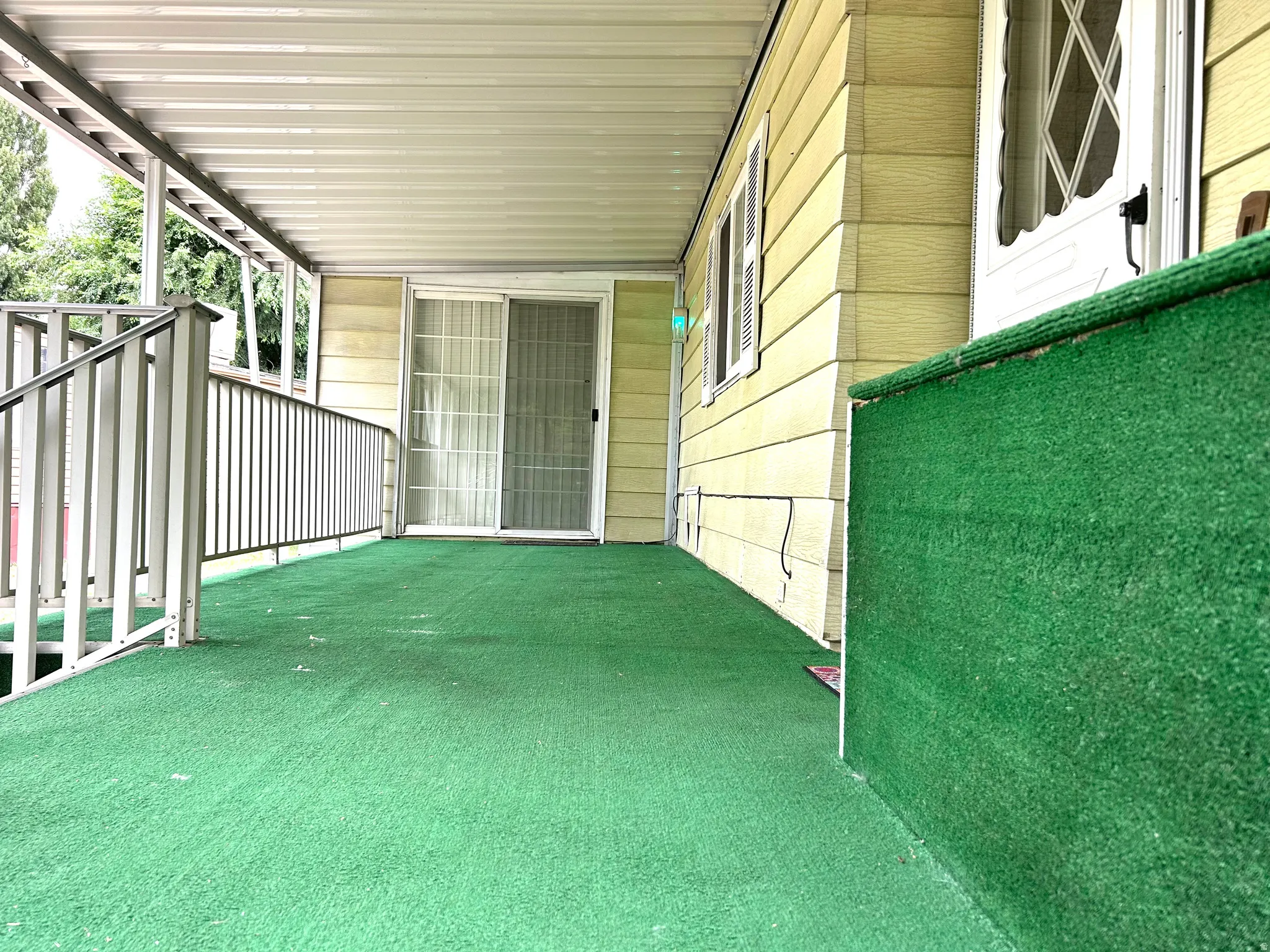 Covered porch with green outdoor carpeting