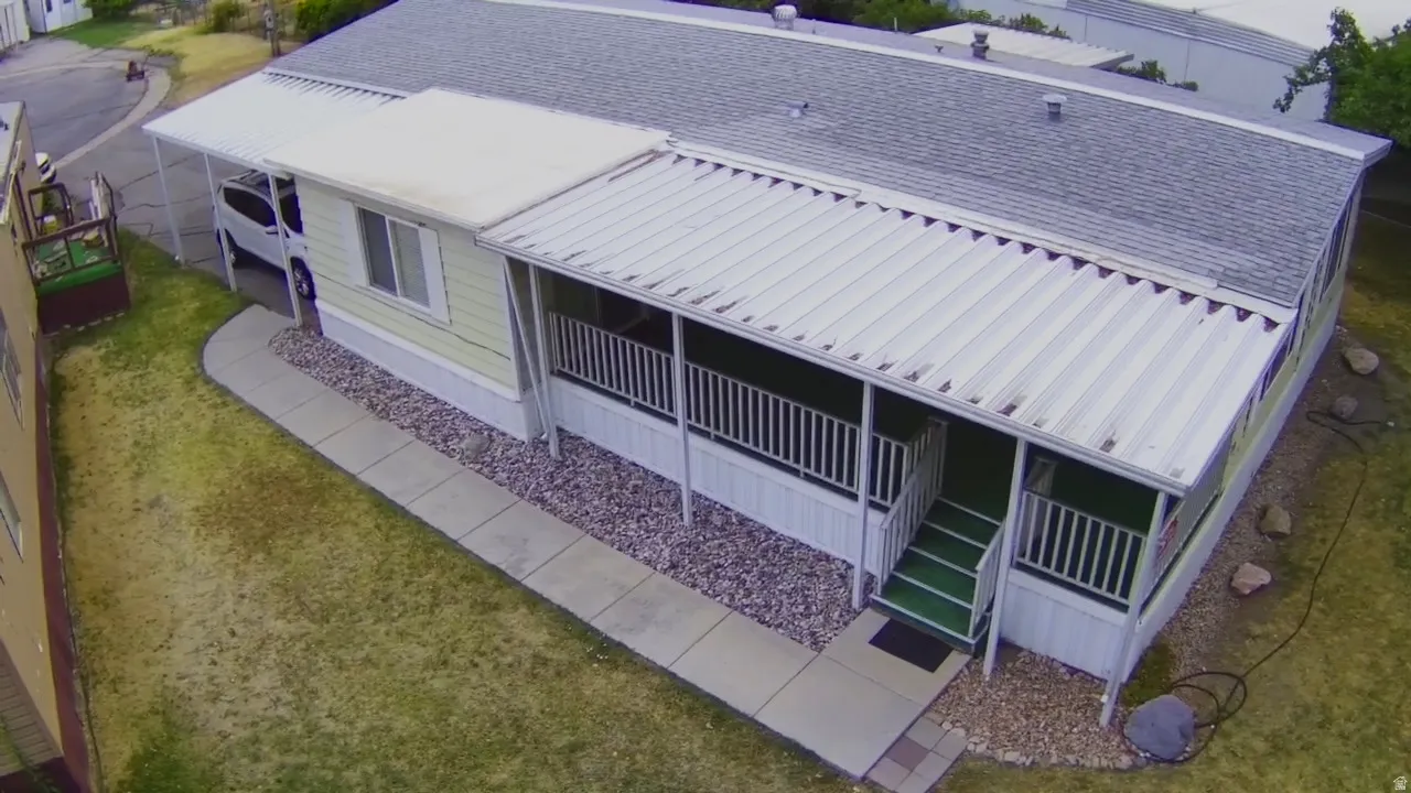 Exterior with light yellow siding, covered front porch, carport, and gravel landscaping