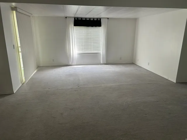 Carpeted empty room with baseboards