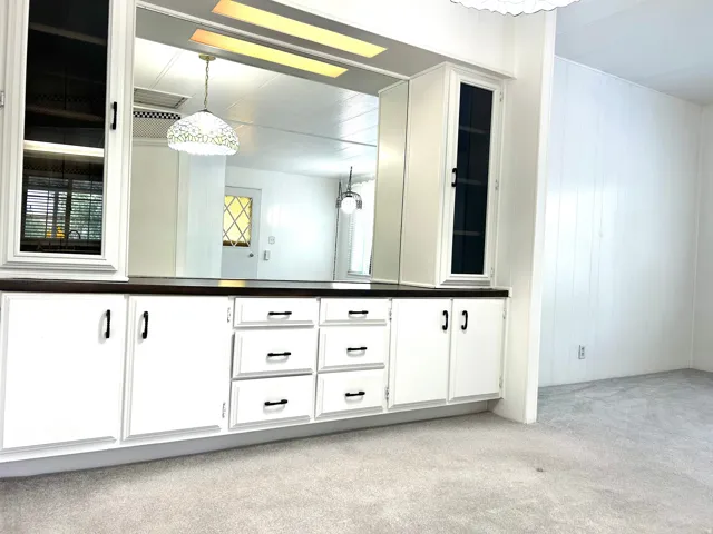 Built-in white cabinetry with a dark wood-finish countertop
