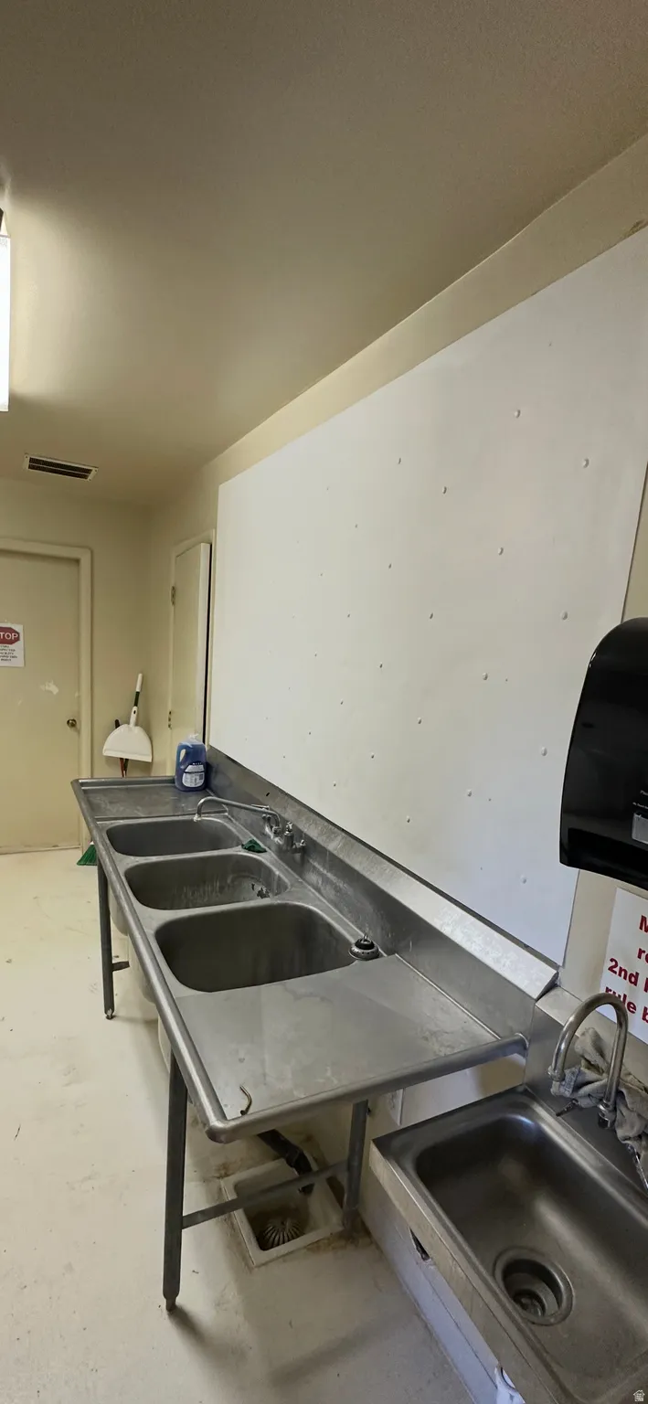Laundry area with a sink and concrete floors