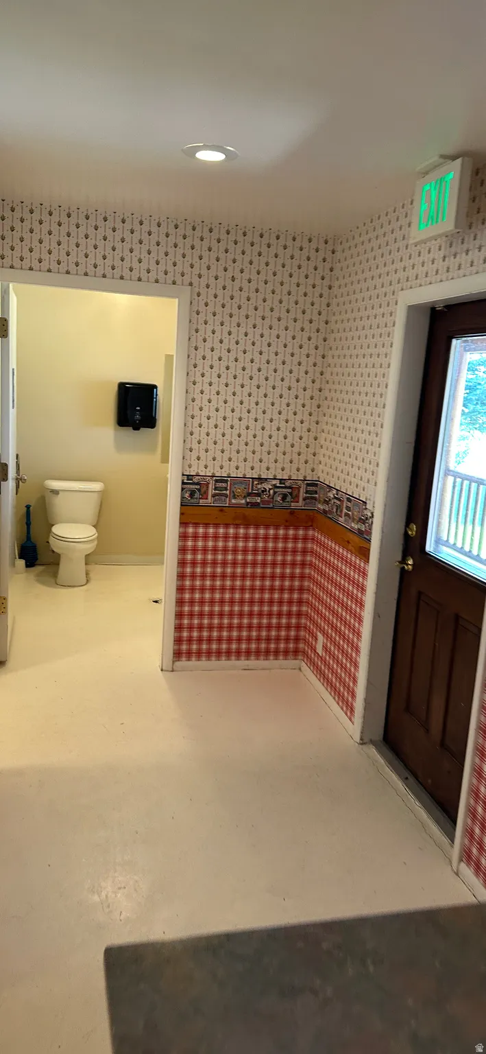 Bathroom featuring toilet and wallpapered walls
