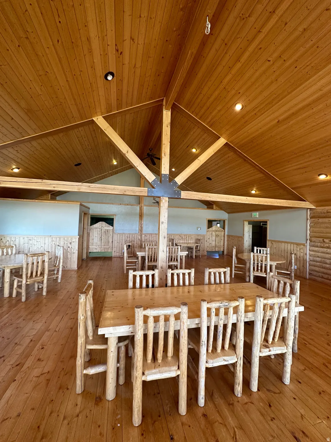 Dining area featuring wood-type flooring, a wooden ceiling with exposed beams, a wainscoted wall, and recessed lighting