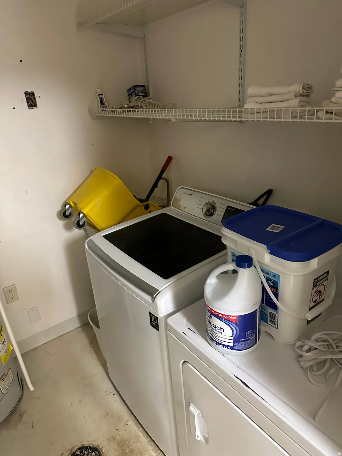 Laundry room featuring washer and clothes dryer and concrete floors