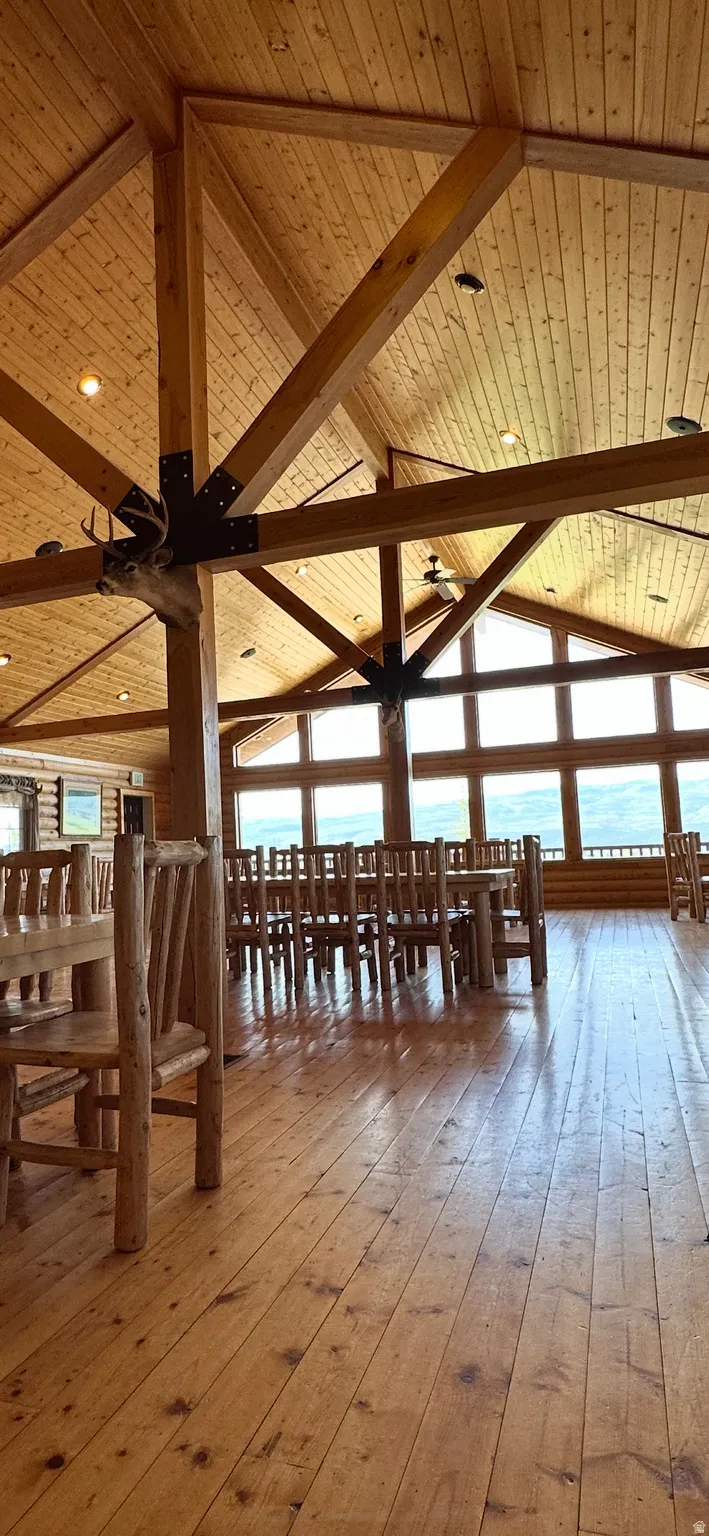 Interior space with healthy amount of natural light, light wood finished floors, and a high wood beamed ceiling