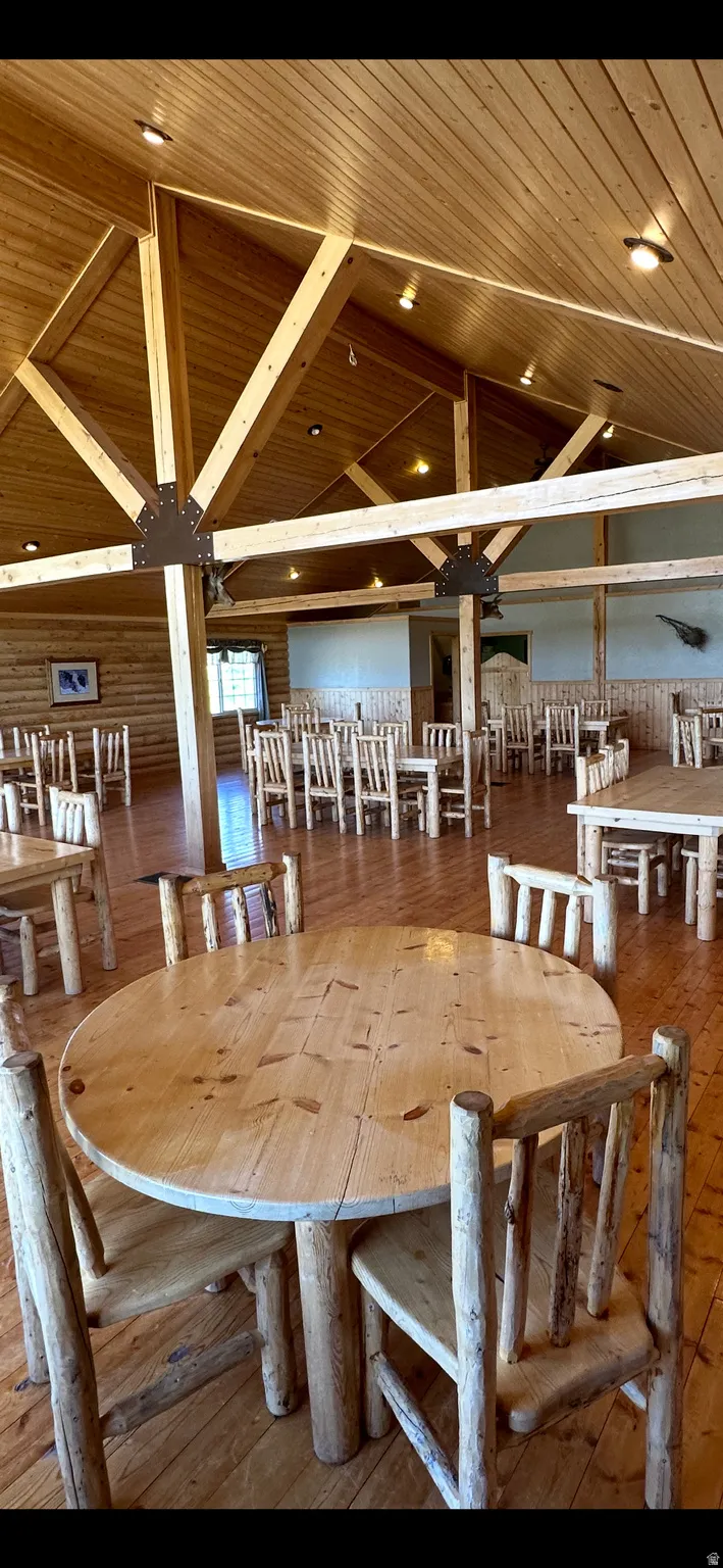 Dining room with a vaulted wood ceiling and hardwood / wood-style flooring