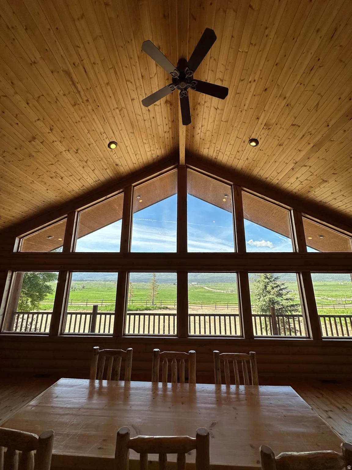Dining room with plenty of natural light, recessed lighting, a ceiling fan, log walls, and wood ceiling