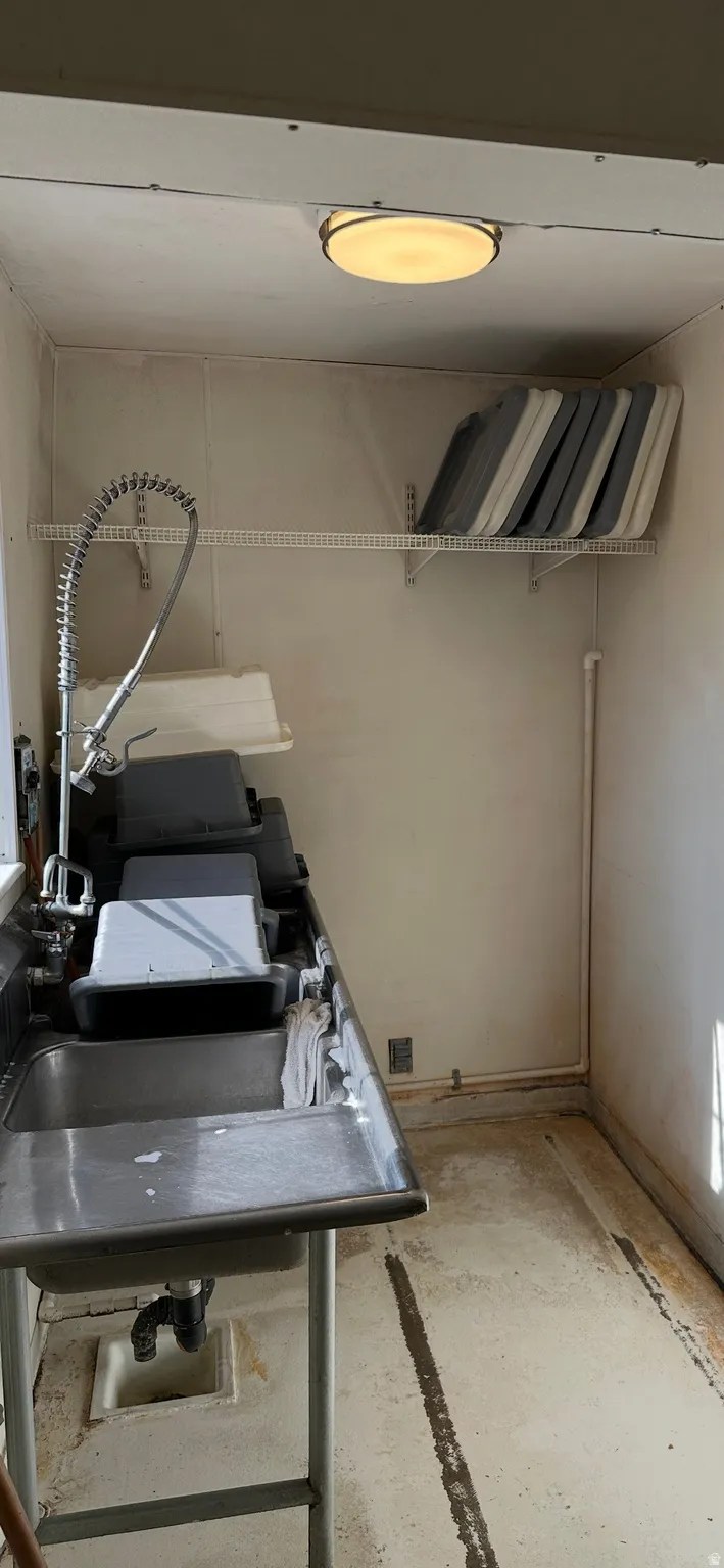 Laundry room featuring a sink and concrete floors