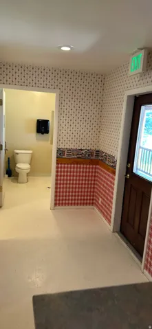 Bathroom featuring toilet and wallpapered walls