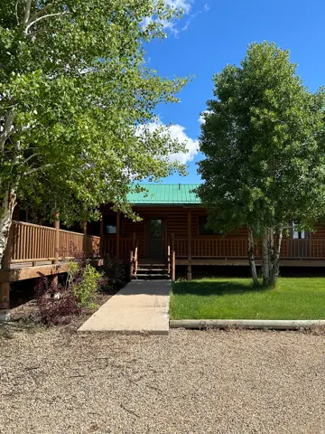 Log cabin featuring a metal roof and a porch