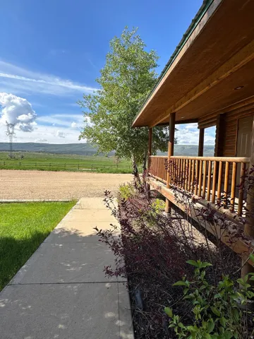 View of yard featuring a rural view and covered porch