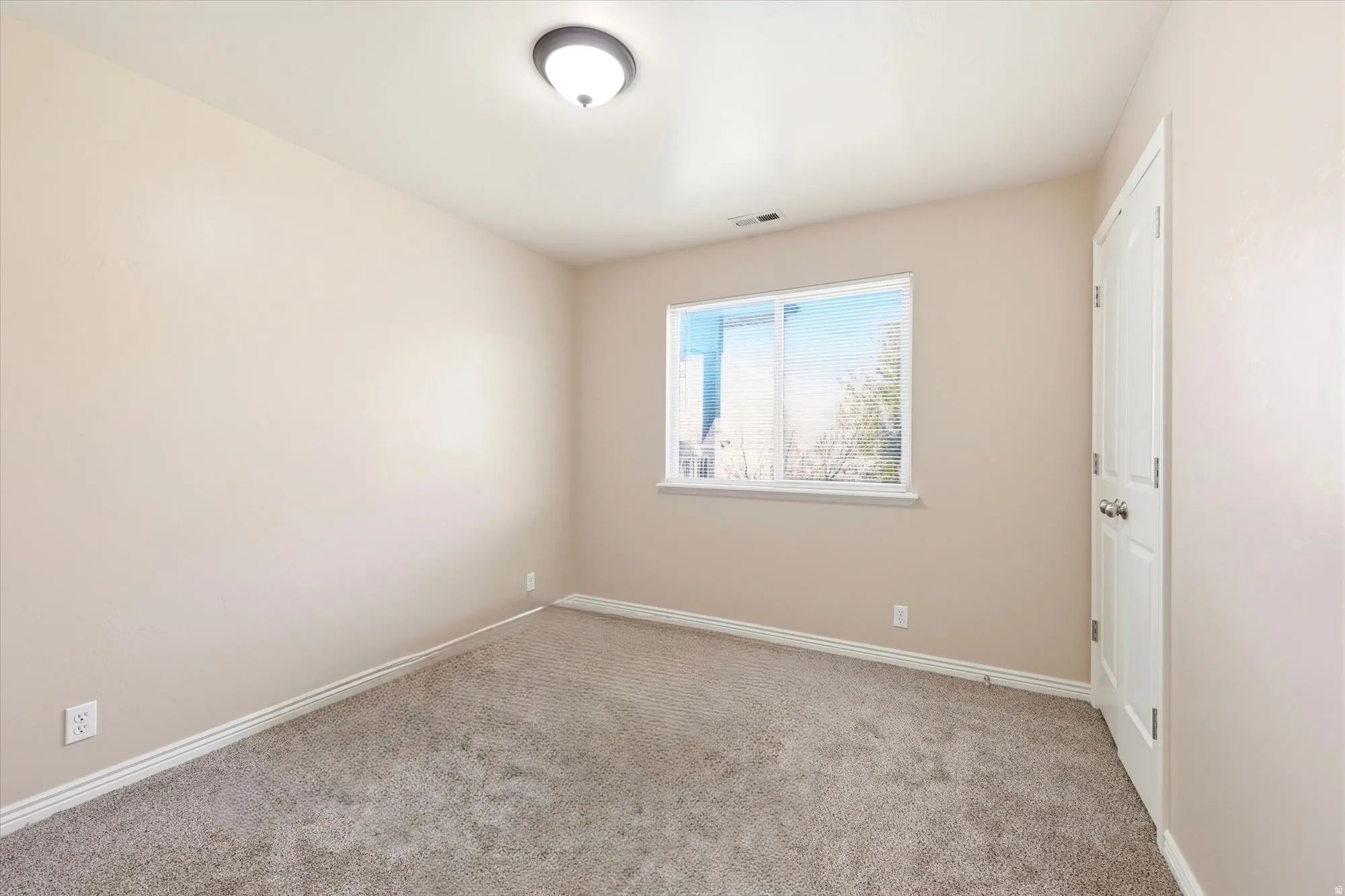 Carpeted spare room featuring baseboards