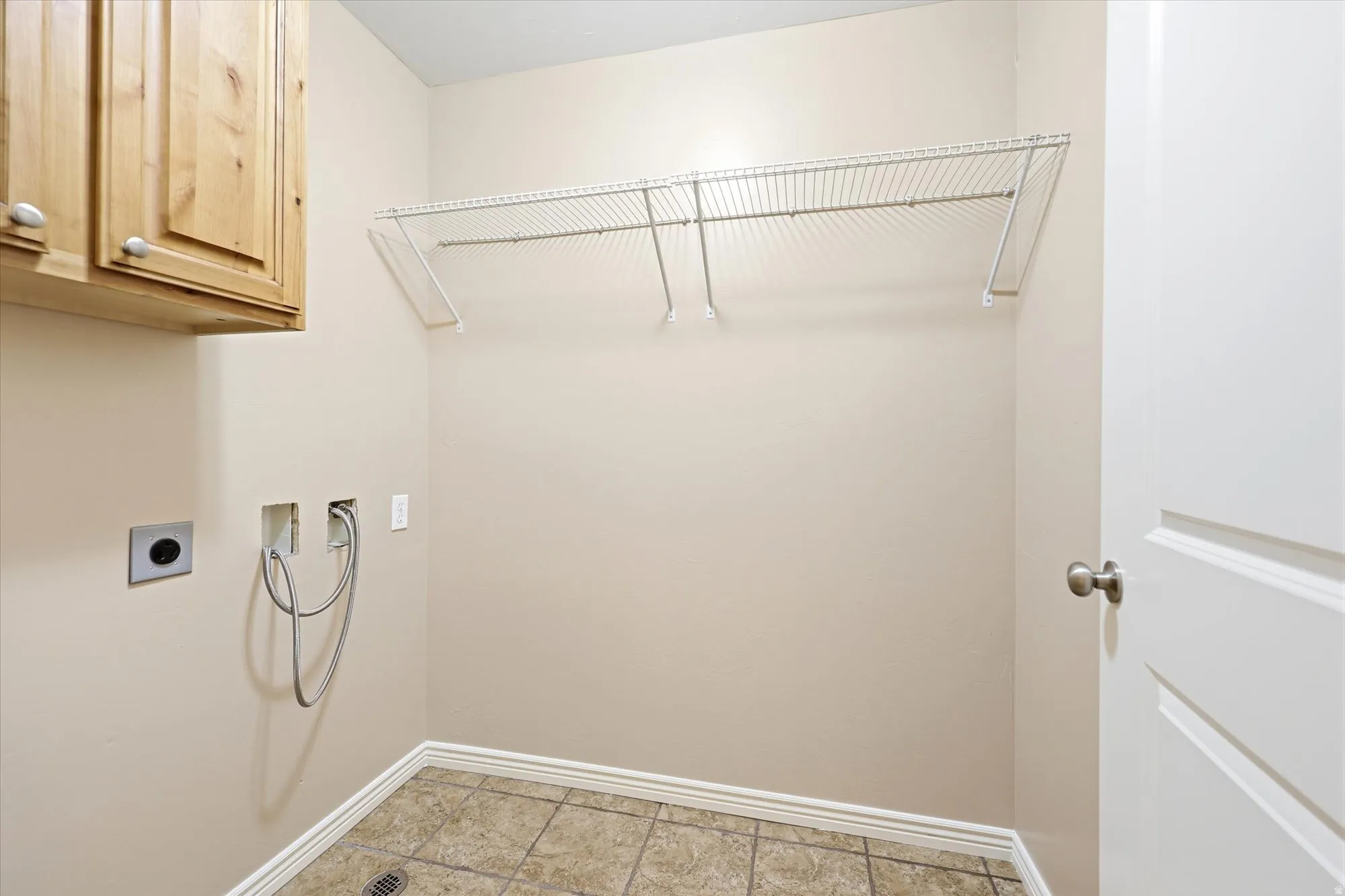 Laundry area featuring washer hookup, electric dryer hookup, and cabinet space