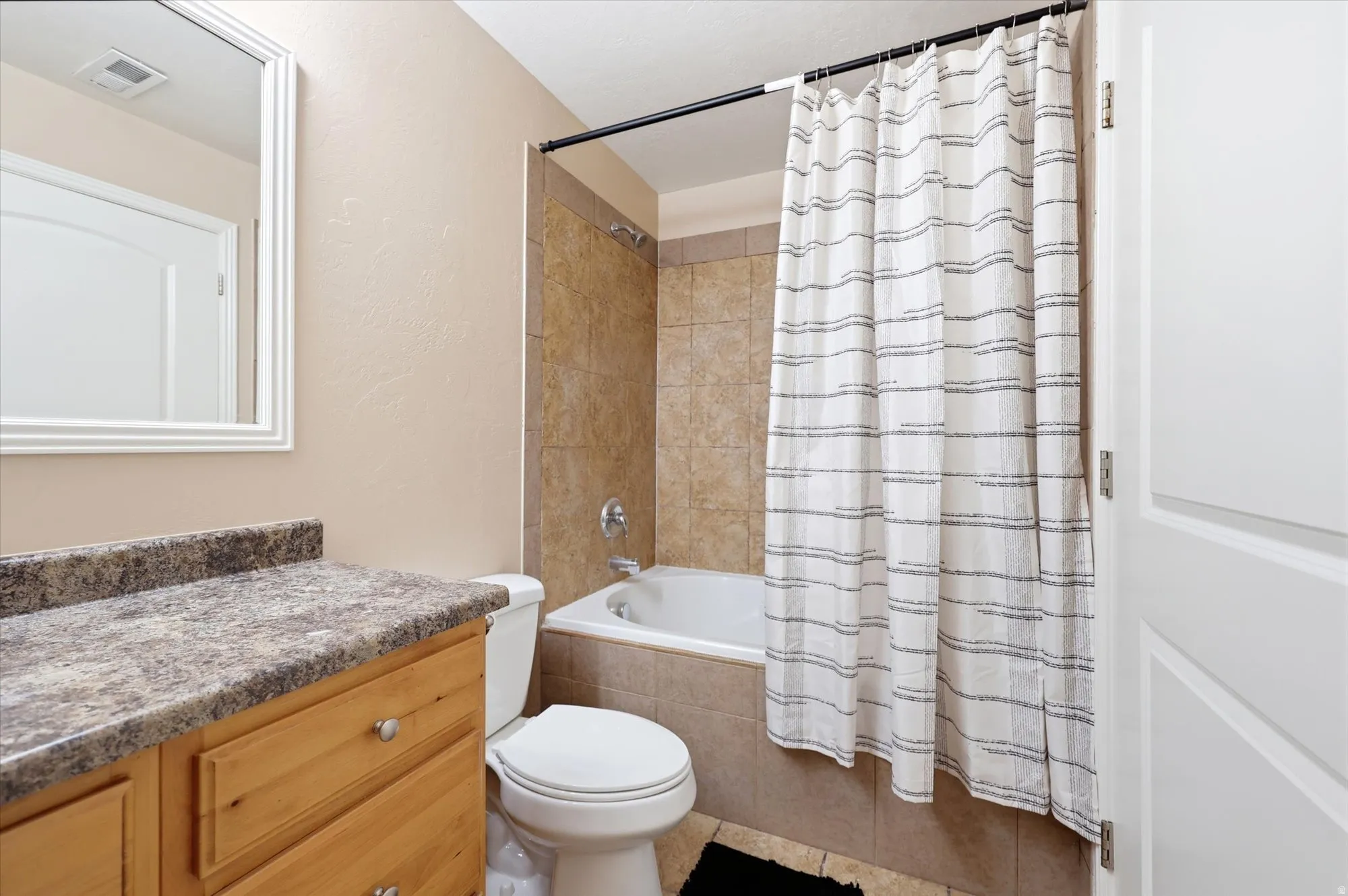 Bathroom featuring vanity and tiled shower / bath combo