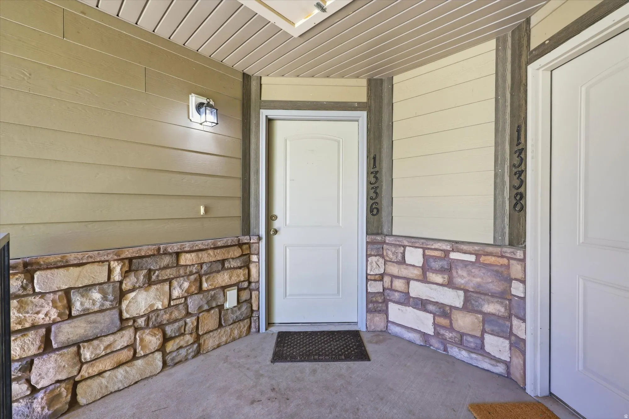 Entrance to property with stone siding